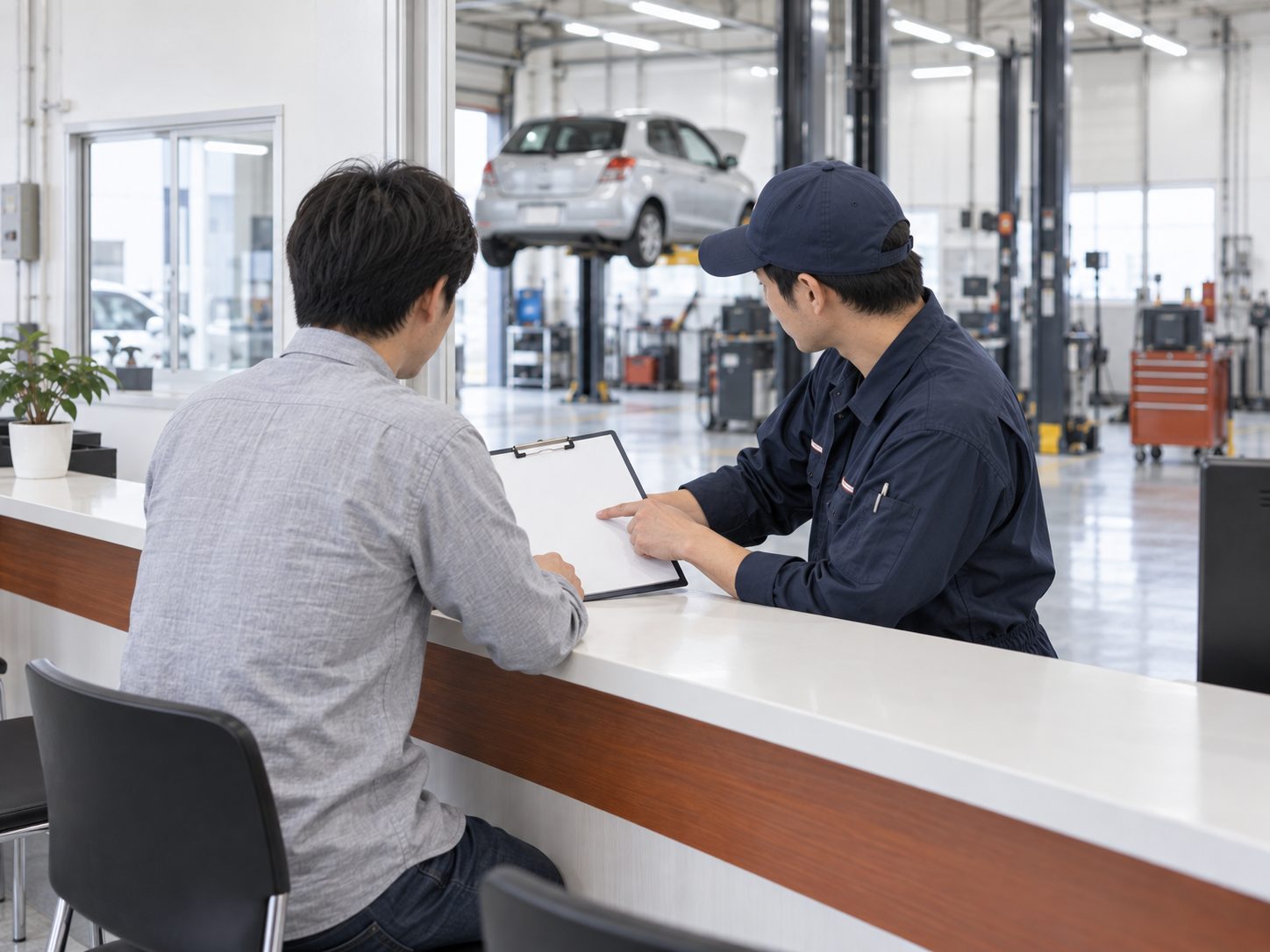 受付カウンター越しにお客様へ説明する整備士